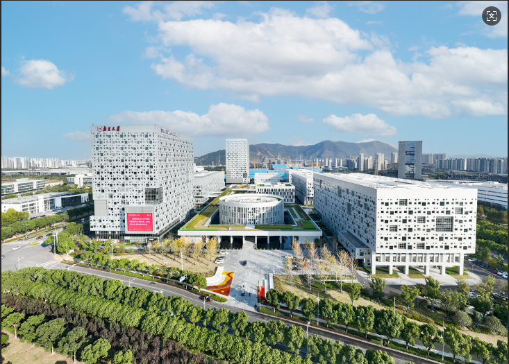 A green and brown rural landscape leading into a bright blue ocean and slightly cloudy sky, done in oil paints.